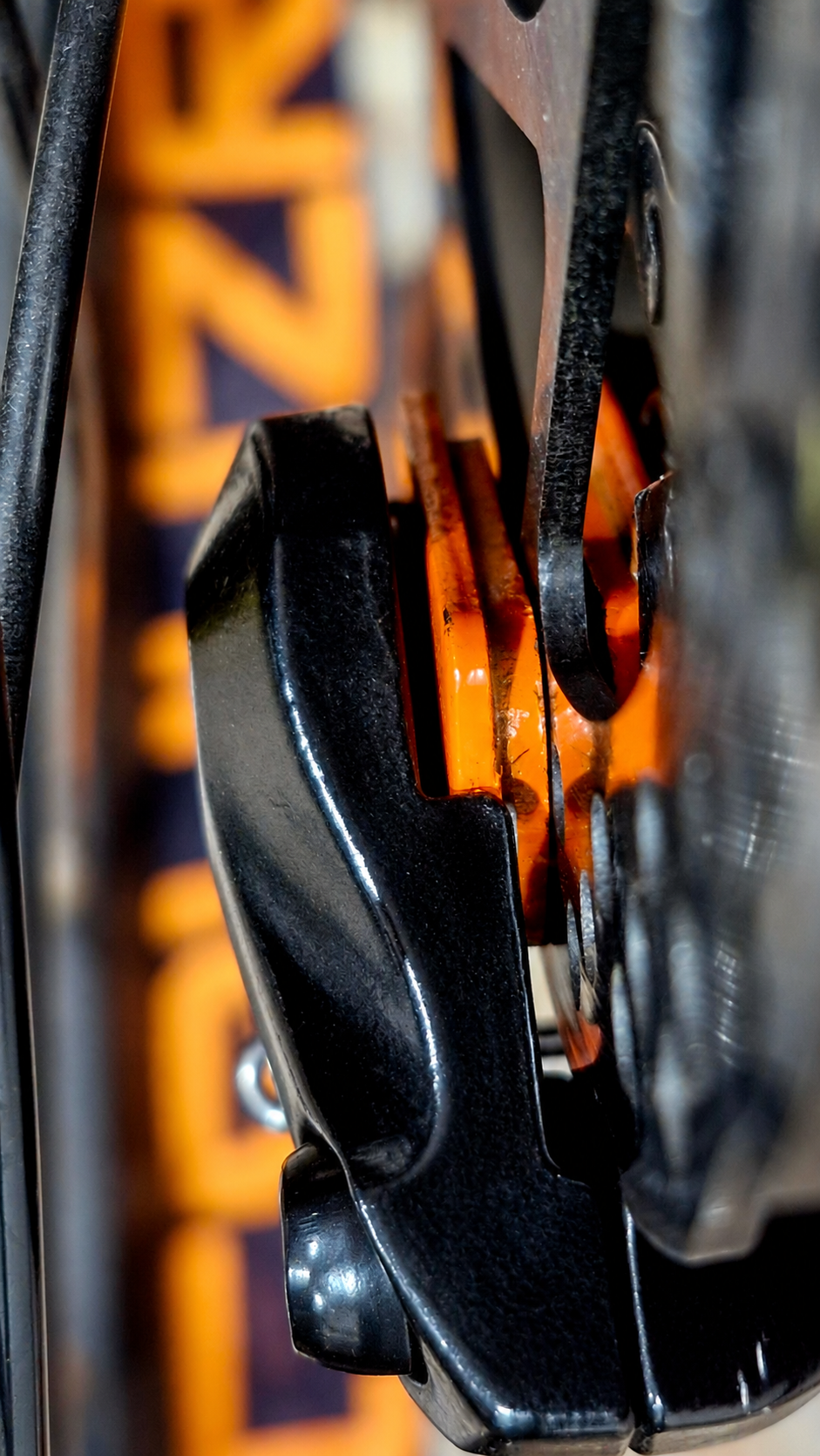 Close-up of a bicycle disc brake with orange CRUUZR details